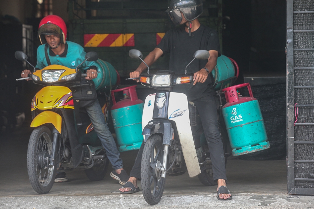 A file photograph shows delivery workers outside a store in Meru, Ipoh, on June 19, 2024. — Picture by Farhan Najib