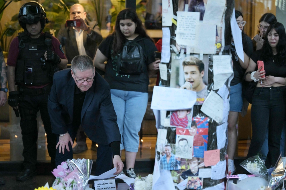 Payne takes a closer look at the tributes left by fans outside CasaSur Hotel in Buenos Aires. — AFP