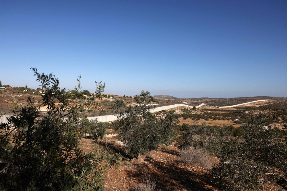 A picture shows Israel's separation barrier passing next to the village of Beit Awa, west of Hebron, in the occupied West Bank on October 19, 2024. — AFP pic