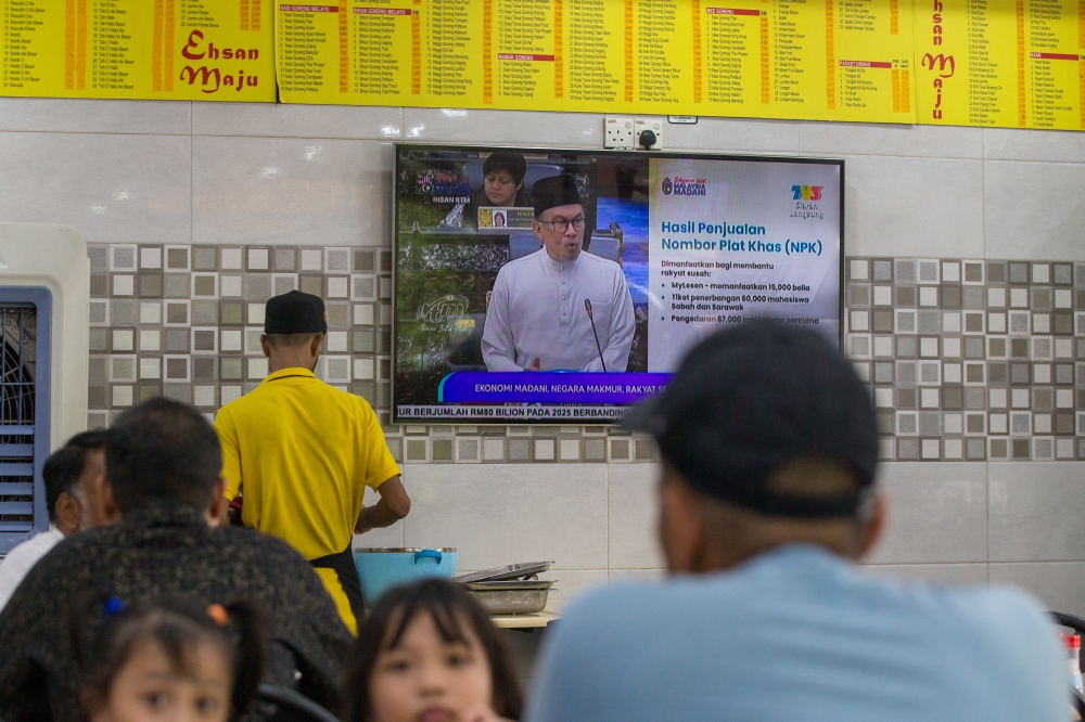 People at a restaurant watch Prime Minister Anwar Ibrahim delivering Budget 2025 on the television. October 18, 2024 — Picture by Raymond Manuel