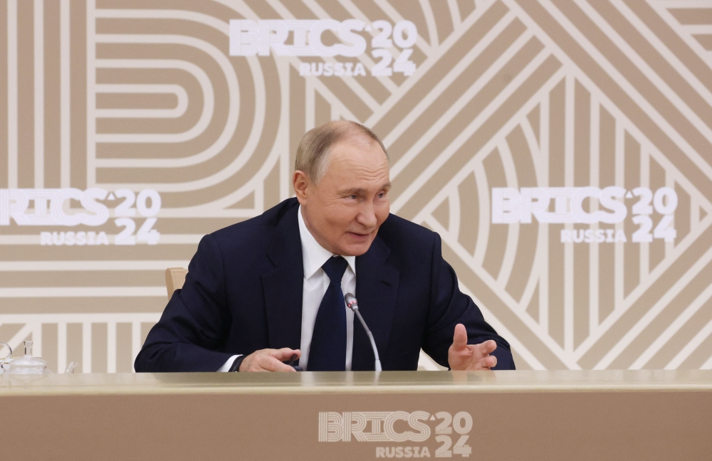 In this pool photograph distributed by the Russian state agency Sputnik, Russia's President Vladimir Putin meets with the heads of leading media outlets from the BRICS member countries in the Moscow region on October 18, 2024. — AFP pic