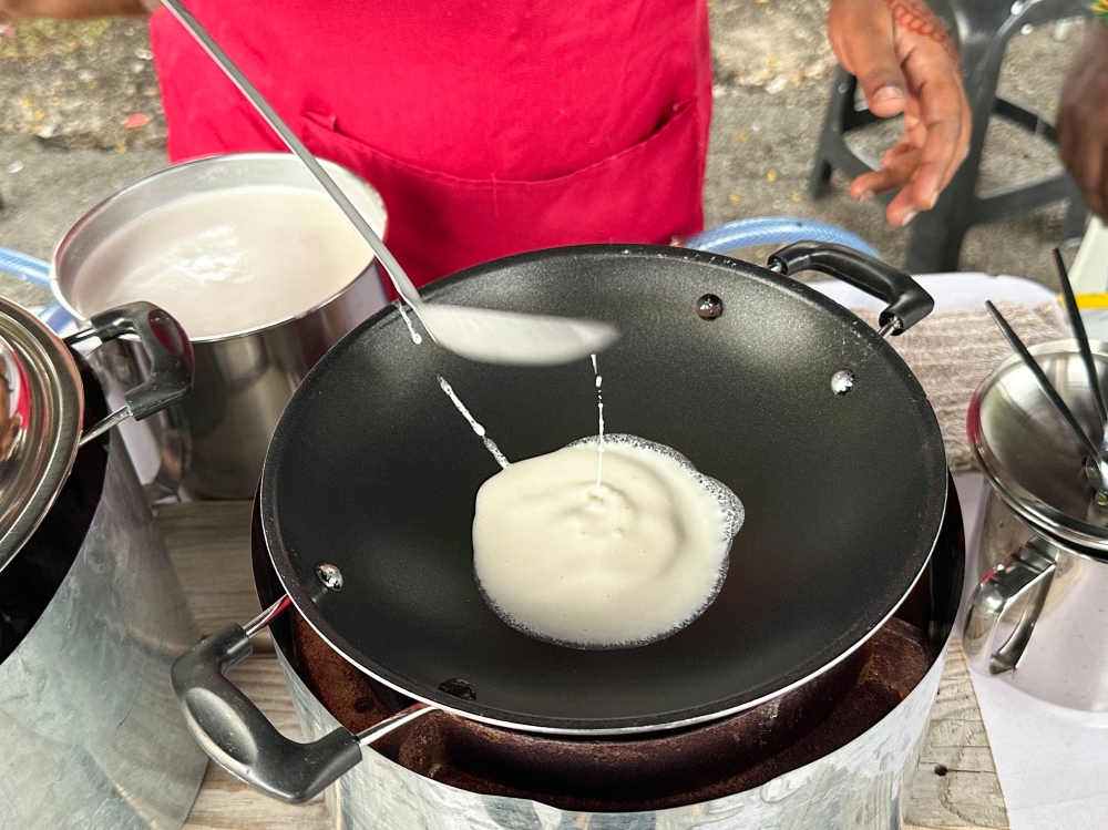 It starts with a scoop of batter made with coconut milk, flour, sugar and eggs. — Picture by Lee Khang Yi