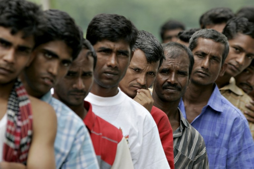 A file photograph showing Bangladeshi workers in line outside the Bangladeshi High Commission in Kuala Lumpur. — AFP pic