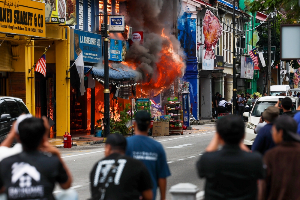 People watch as a fire breaks out along Jalan Besar in Kuantan, on Oct 19, 2024. — Bernama pic