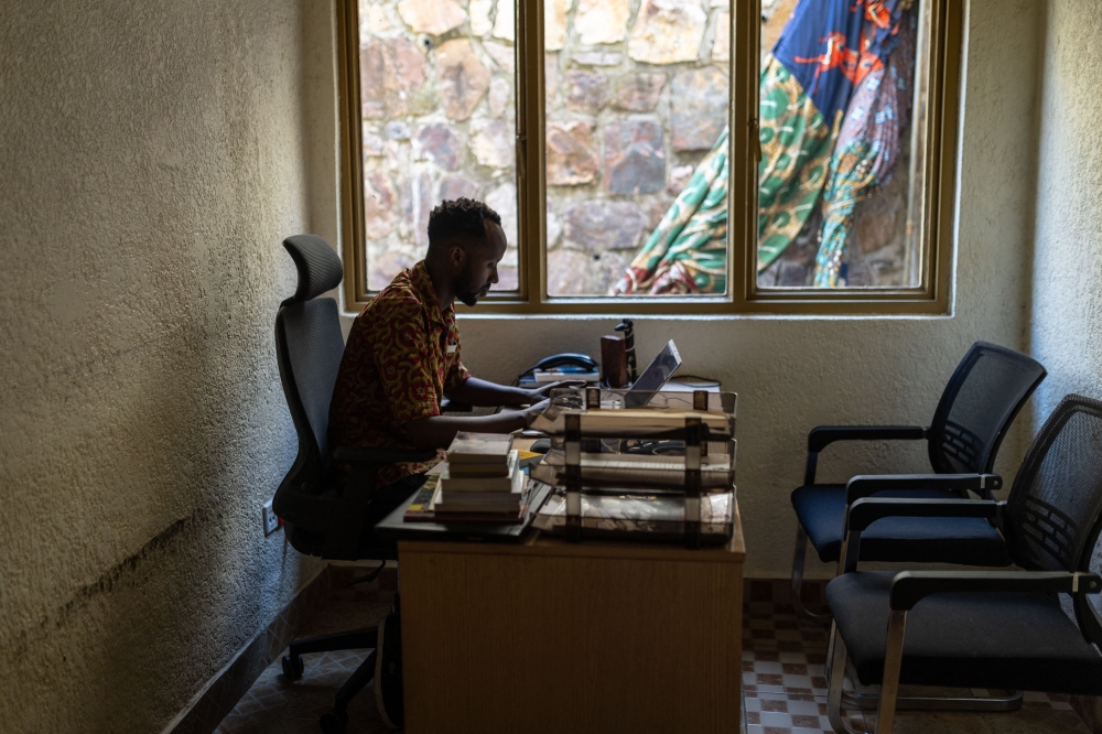 Manzi Rugirangoga works on his laptop at the French cultural center in Kigali on May 26, 2024. Rugirangoga survived the genocide against the Tutsi in 1994 when he was only 1 year old and where he lost his mother and dozens of family members. He got exfiltrated to Burundi through a humanitarian convoy in 1994 and was later raised in France by his father. — AFP pic 