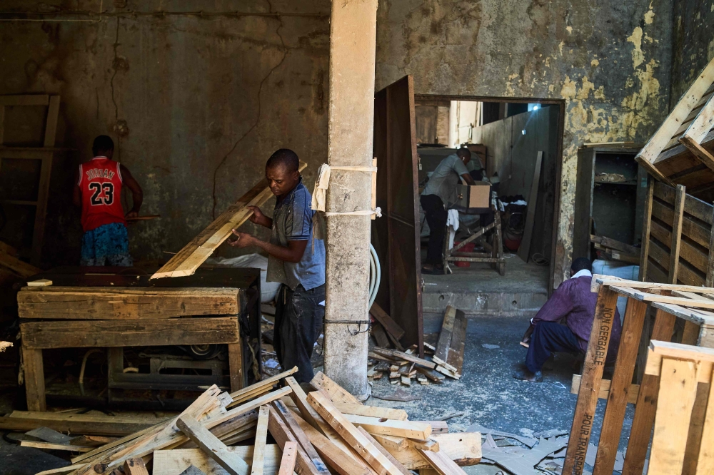 Carpenters work at a coffin manufacturing workshop in downtown Beira on October 10, 2024. In downtown Beira, a dozen young men work under the supervision of 56-year-old Amelia Armando Machava handcrafting coffins from discarded wooden pallets that come into the Mozambique port city on cargo ships. — AFP pic 