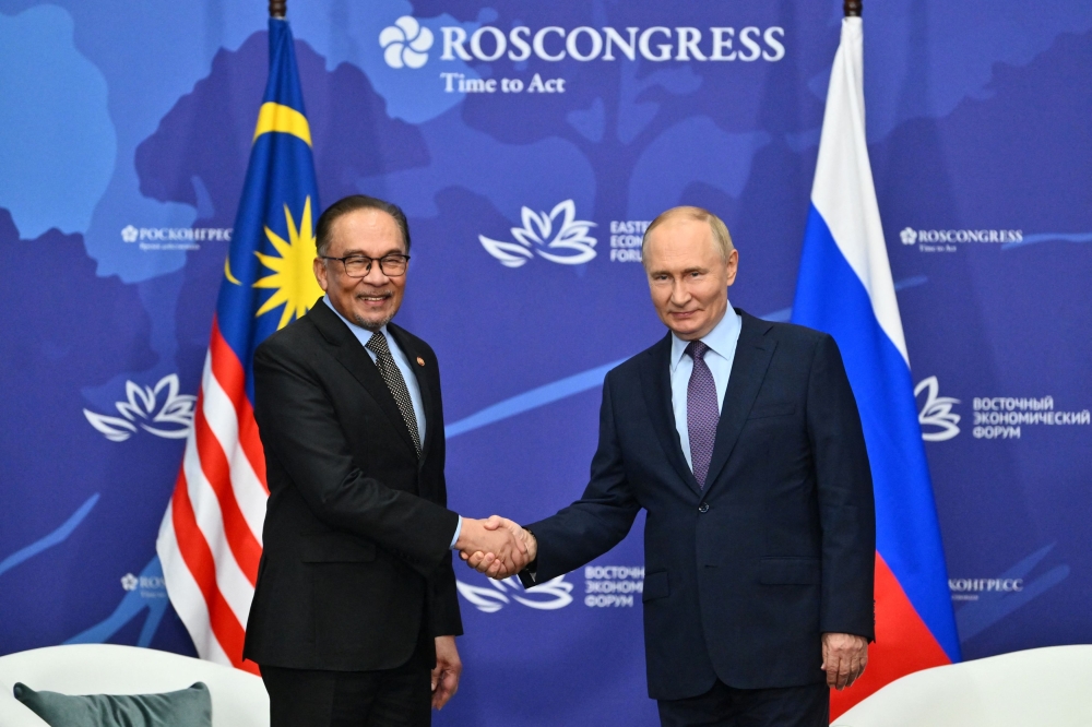 A file photo shows Russian President Vladimir Putin shaking hands with Prime Minister Datuk Seri Anwar Ibrahim in Vladivostok, Russia September 4, 2024. — Reuters pic