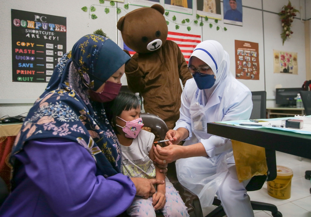 A child is seen getting their Covid-19 vaccination at the Kemas Kindergarten Parliament Parit in Perak February 28, 2022. — Picture by Farhan Najib