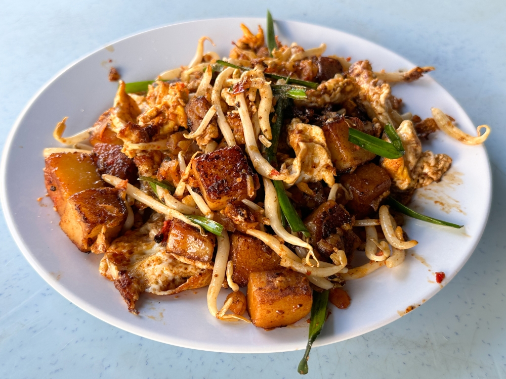 For a more substantial snack, opt for the fried carrot cake where it's a melange of textures from soft radish cake cut into cubes, crunchy bean sprouts, fluffy fried egg and preserved radish. — Picture by Lee Khang Yi