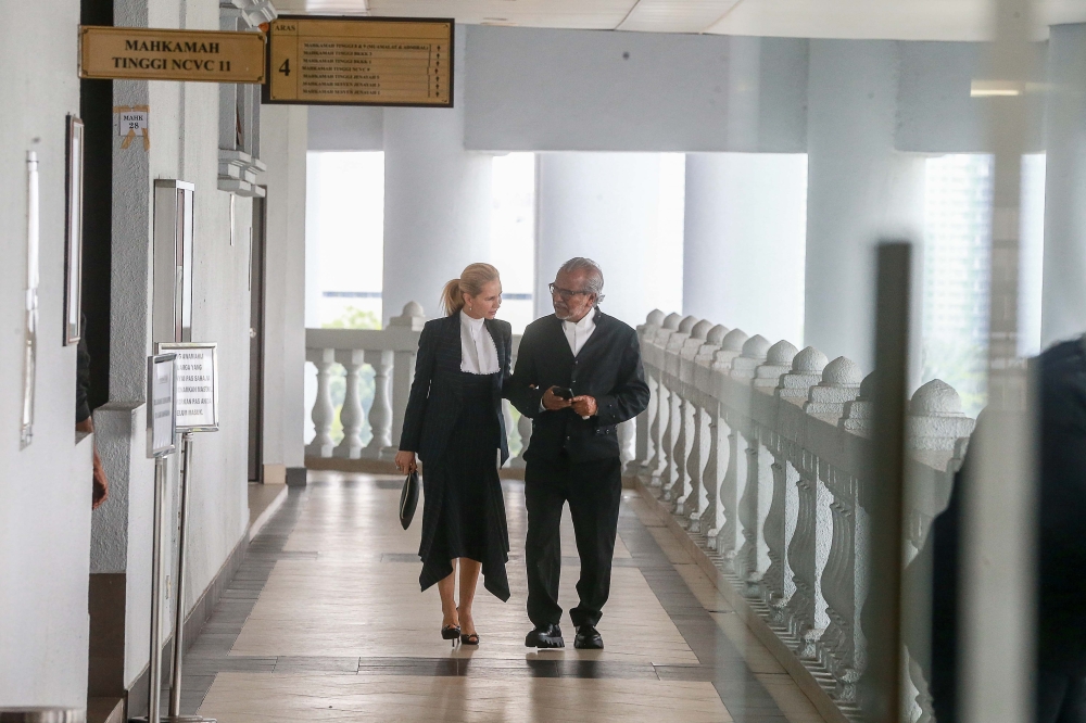 Tan Sri Shafee Abdullah confers with Tania Scivetti outside the courtroom at the Kuala Lumour Court Complex about their client, former prime minister Datuk Seri Najib Razak who must now enter his defence in the 1MDB corruption and money laundering trial. — Picture by Sayuti Zainudin