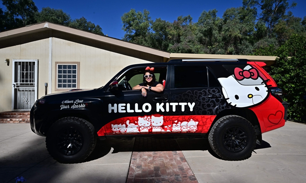 In this picture taken on October 19, 2024, Helen, founder of the ‘Hello Kitty SoCal Babes’ fan club, poses in her decorated vehicle in Riverside County, California. — AFP pic