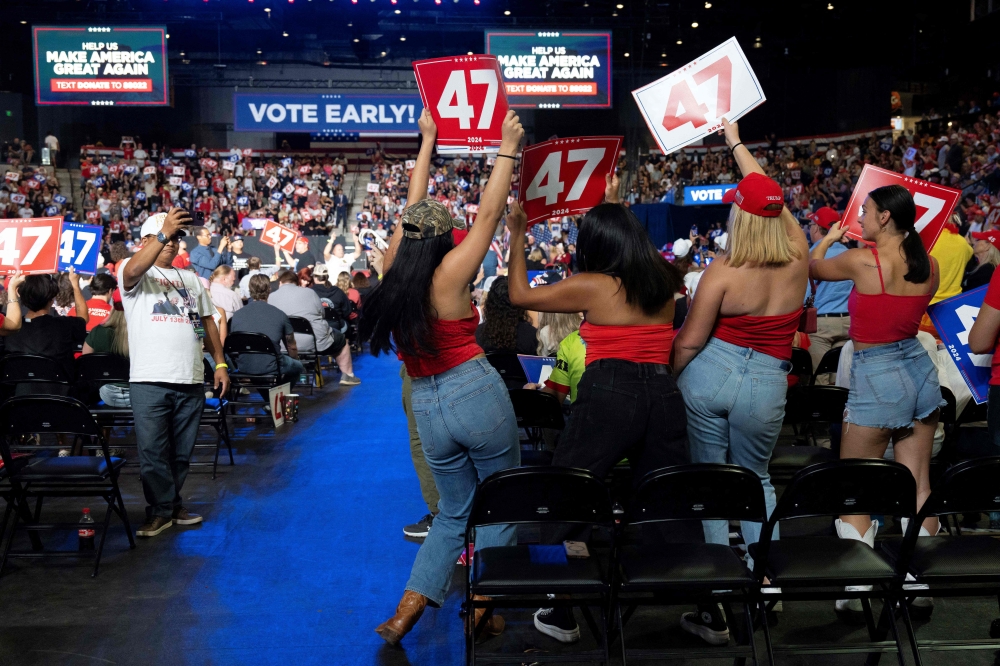 Young women do the YMCA dance during a campaign rally for Republican presidential nominee former president Donald Trump at Mullet Arena in Tempe, Arizona, on October 24, 2024. — AFP pic