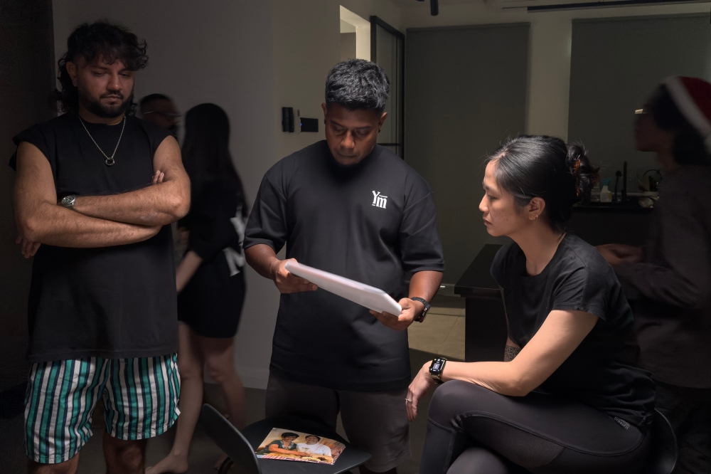 Sher ‘bflat’ Mohamed (left) Vinoth Raj Pillai (centre) discussing the ad script with their team. — Picture by Vinoth Raj Pillai