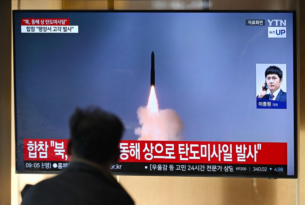 A man watches a television screen showing a news broadcast with file footage of a North Korean missile test, at a train station in Seoul on October 31, 2024. North Korea on October 31 fired a ‘long-range ballistic missile’, South Korea's military said, Pyongyang's first weapons test since Seoul accused it of sending tens of thousands of soldiers to Russia. — AFP pic