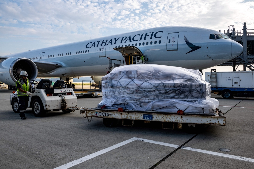 Luggage is transferred to a Cathay Pacific flight for departure in Kansai International Airport of Osaka Prefecture. — AFP pic