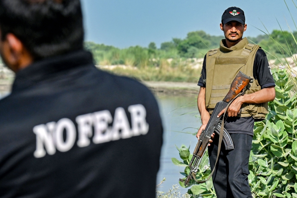 This photograph taken on October 9, 2024 shows elite police personnel patrolling on a sandy island along the Indus river, in the ‘Katcha lands’ at Rahim Yar Khan district. Somewhere in central Pakistan, Shahid Lund Baloch is hiding out in riverine terrain which has long offered refuge to bandits —  using the internet to enthrall citizens even as he preys on them, police say. — AFP pic