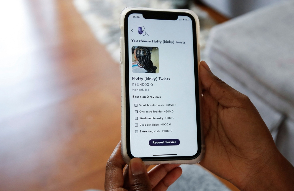 Steffi Mwanzia shows a phone screen displaying the 'Braiding Nairobi' app, where she requested braiding services at her house, in Ruaka, Kiambu county, Kenya October 3, 2024. — Reuters pic  