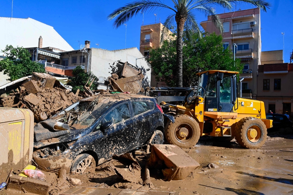 A bulldozer is used to clear vehicles from streets in the town of Catarroja, in the region of Valencia, eastern Spain, on November 2, 2024. — AFP pic