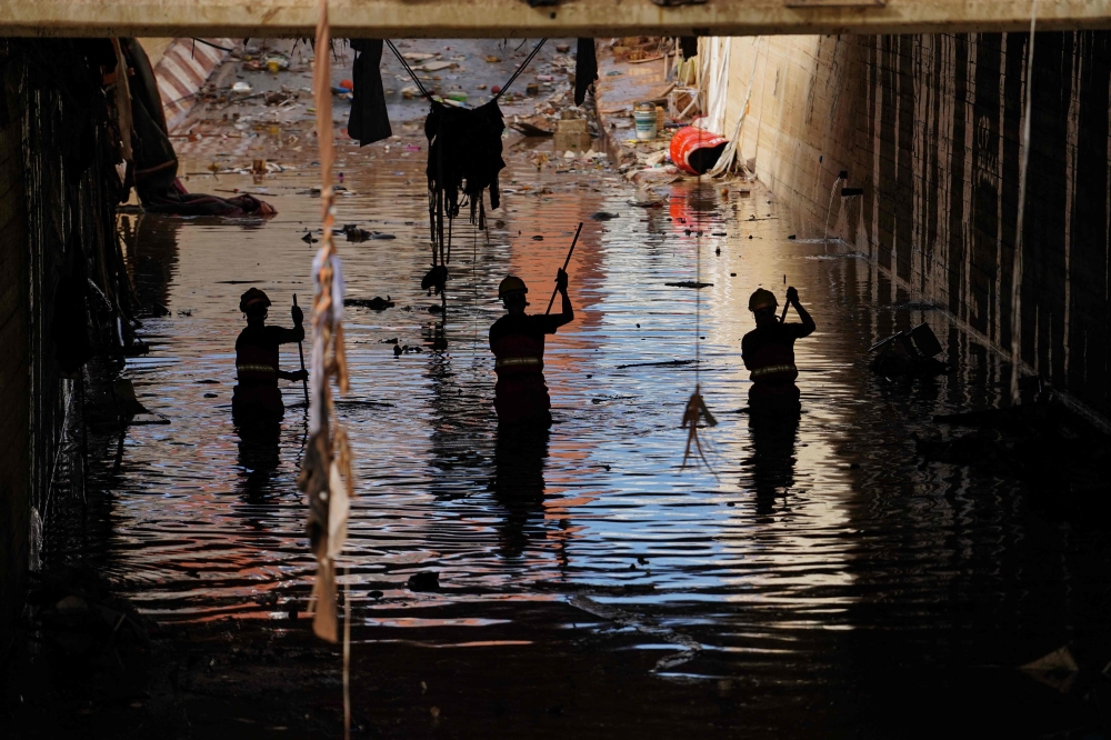 Firefighters search for bodies amongst the debris on November 2, 2024, in the aftermath of deadly floods in the town of Alfafar. — AFP pic