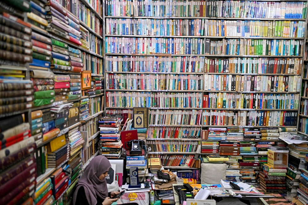 This photograph taken on October 22, 2024 shows a student sitting amid Urdu books stacked at the Hazrat Shah Waliullah public library, in Urdu Bazar in the old quarters of Delhi. — AFP pic 