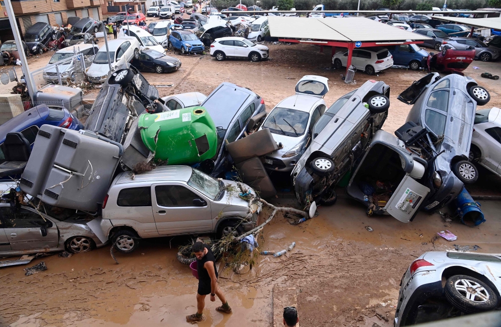 Cars and debris pile up on the streets of Paiporta. — AFP pic