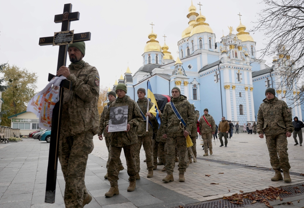 Ukrainian servicemen carry the coffin with the body of Andriy Romanyuk, 26, a volunteer soldier of the separate assault battalion 