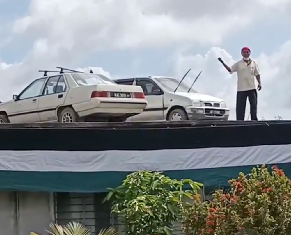 Awang Ali said he enlisted his son to help lift a Proton Saga and a Perodua Kancil onto the roof in just half an hour using a crane last Thursday. — Picture via Facebook