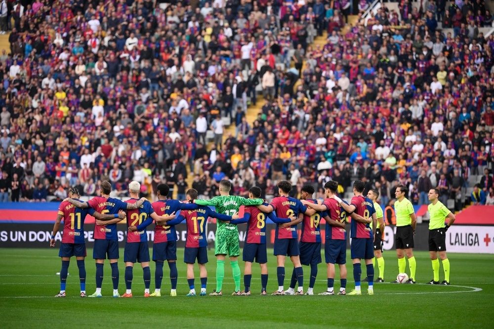 FC Barcelona players observe a minute of silence for the flood victims in the Valencia region before the start of the Spanish league football match between FC Barcelona and RCD Espanyol at the Estadi Olimpic Lluis Companys in Barcelona, on November 3, 2024. — AFP pic