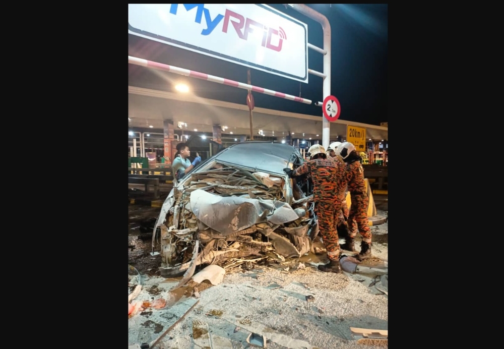 Firemen extricate the bodies of the victims. Two men were killed after their vehicle crashed into a lane divider at the Sungai Besi Toll Plaza heading towards Seremban early this morning. — Picture from X/Bernama