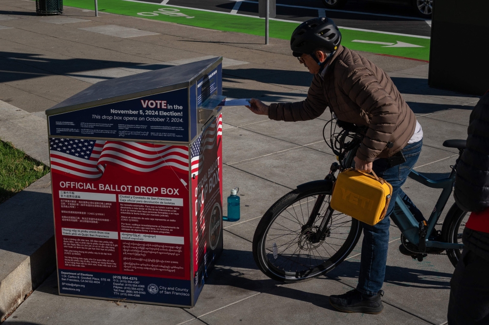 A voter drops off ballots at an official ballot drop box on the final day of early voting ahead of Election Day at City Hall on November 4, 2024 in San Francisco, California. — AFP pic