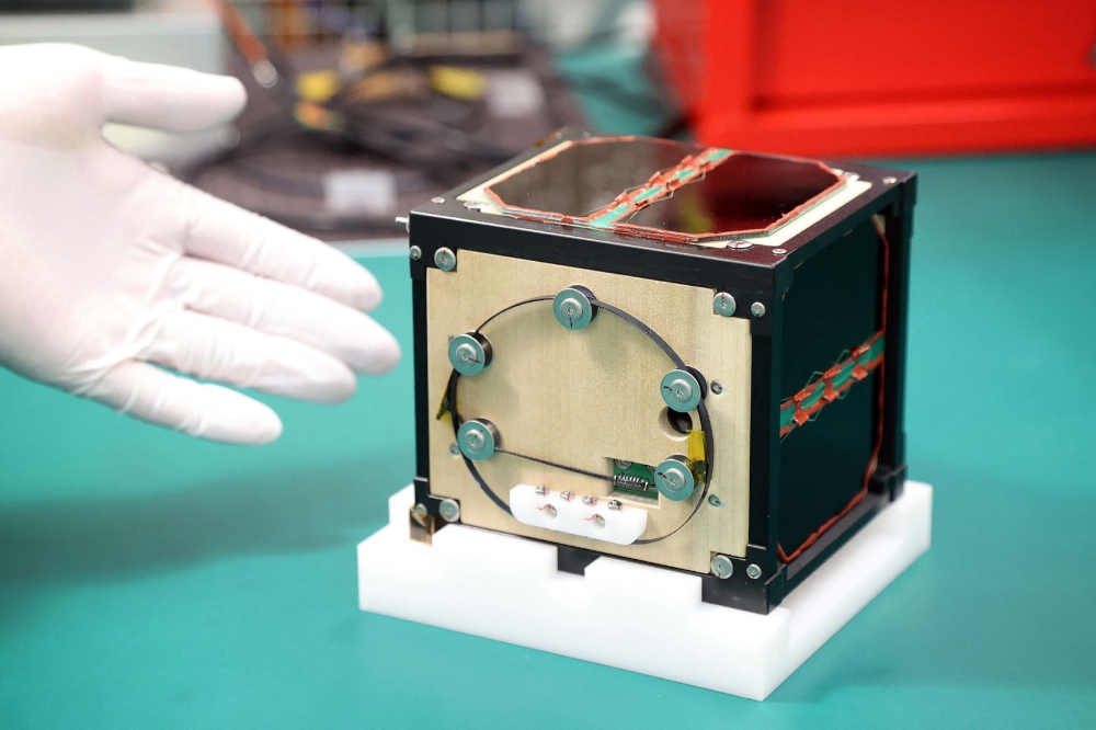 This file photo taken on May 28, 2024 shows the world’s first satellite made from wood, named LignoSat, developed by scientists at Kyoto University and logging company Sumitomo Forestry, during a press conference in Kyoto. — AFP pic