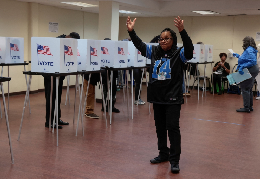 A poll worker motions to voters waiting to cast their votes during early voting in the U.S. presidential election at a polling station in Detroit, Michigan, U.S. November 3, 2024. — Reuters pic