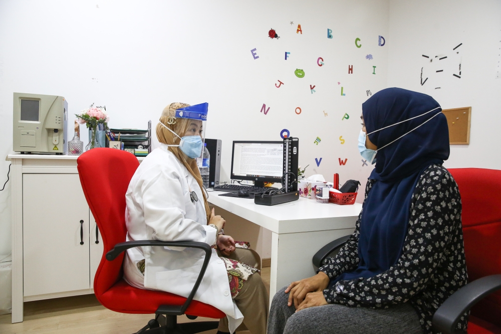 A doctor listens to a patient during a consultation at the Selcare Clinic in Shah Alam, Selangor. — Picture by Yusof Mat Isa