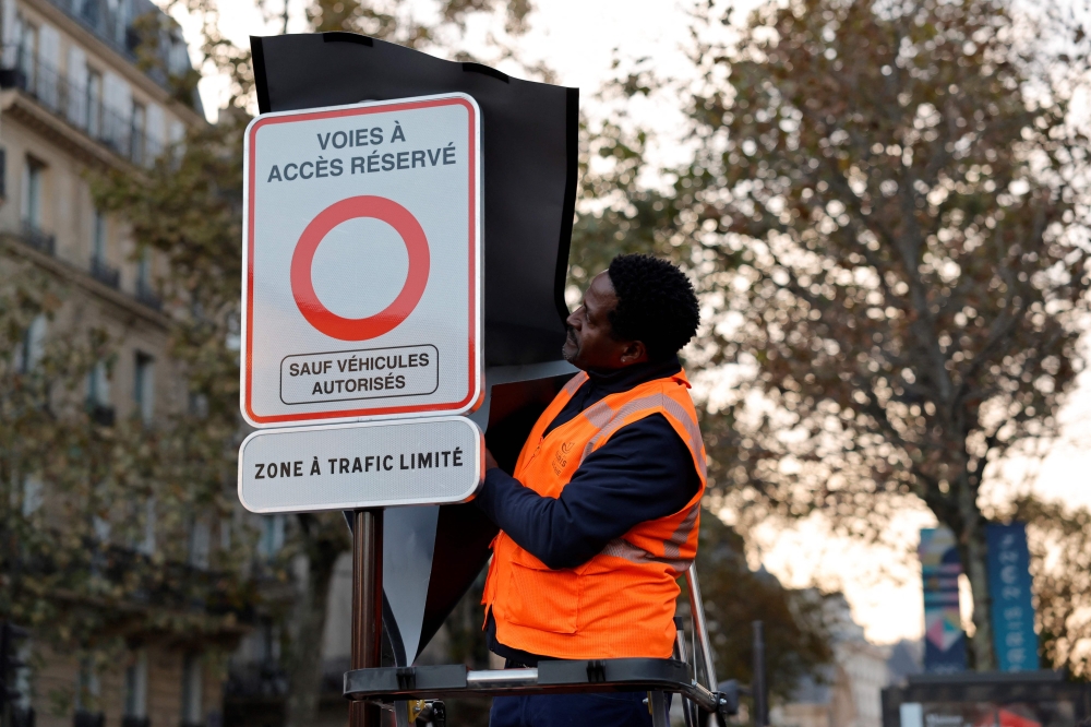 A city employee unveils a traffic sign indicating the limited traffic zone (ZTL). — AFP pic