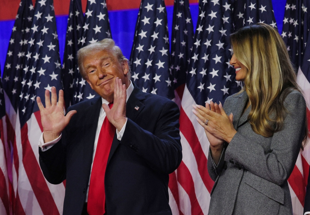 Republican presidential nominee and former US president Donald Trump gestures while accompanied by his wife Melania at his rally in West Palm Beach, Florida, November 6, 2024. — Reuters pic