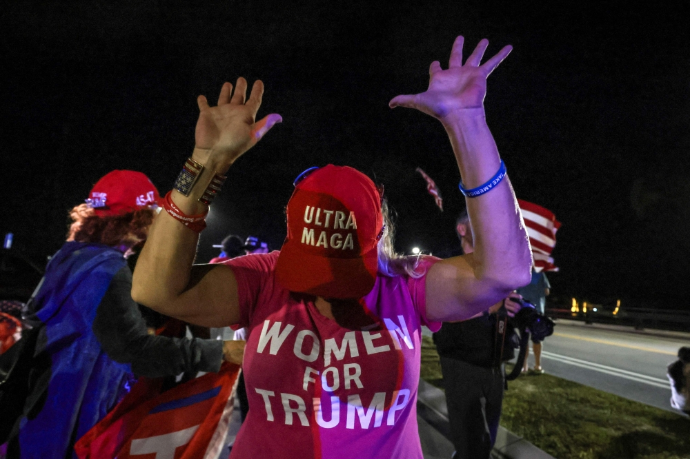 A supporter of former US president and Republican presidential candidate Donald Trump gestures as they gather near his Mar-a-Lago resort in Palm Beach, Florida, on Election Day, November 5, 2024. — AFP pic