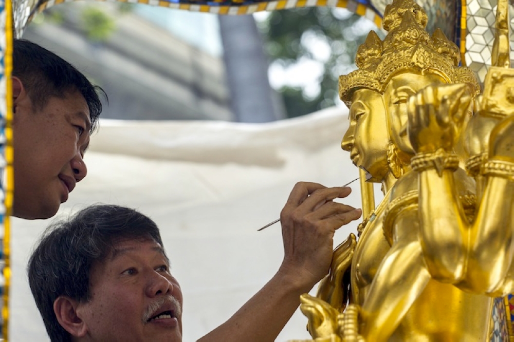 Craftsmen fix the statue of Hindu god Brahma after it was damaged during the deadly blast at the Erawan shrine in Bangkok August 26, 2015. — Reuters pic