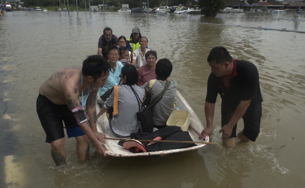 Volunteers wade through flood waters to guide boats ferrying flood victims in Penang November 5, 2017. — Picture by Sayuti Zainuddin