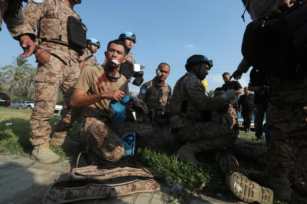 An injured member of the Malaysian battalion of the United Nations Interim Force In Lebanon (UNIFIL), sits on the ground after he was injured at the site of an Israeli airstrike at the northern entrance of the southern Lebanese city of Sidon, on November 7, 2024. — AFP pic