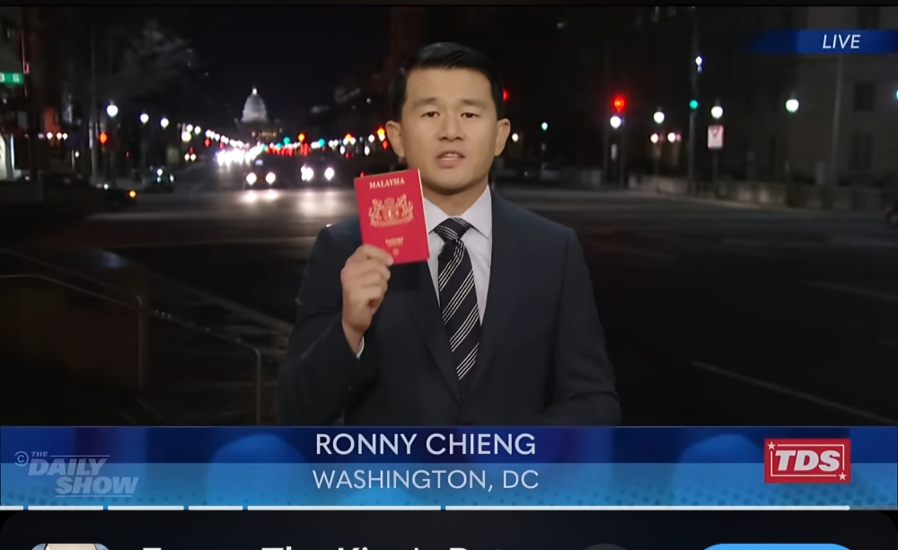 Malaysian-born comedian Ronny Chieng showing his Malaysian passport on The Daily Show. — Picture Via YouTube 