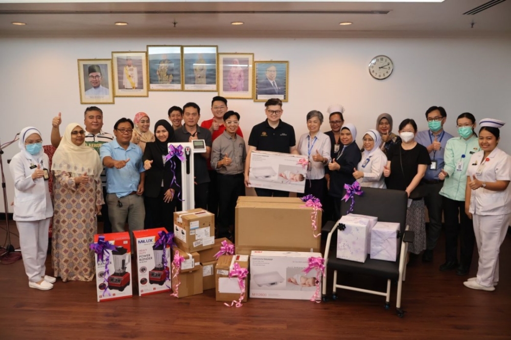 Dr Yii (front, seventh left) hands over the donations to representatives of SGH. — Borneo Post pic