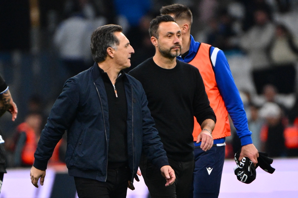 Marseille's Italian head coach Roberto De Zerbi (right), next to Auxerre's French head coach Christophe Pelissier (left) at the end of the French L1 football match between Olympique de Marseille  and AJ Auxerre. — AFP