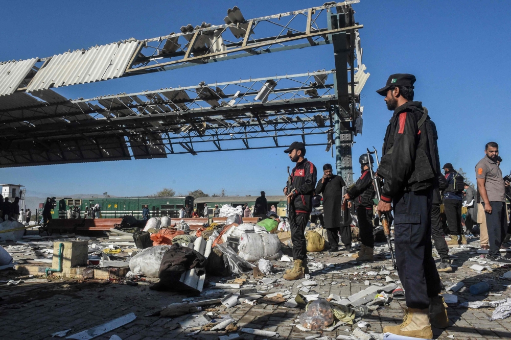 Security personnel inspect the blast area after the explosion. — AFP