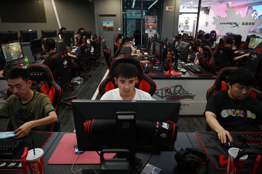 People play computer games at an internet cafe in Beijing on September 10, 2021. Unlike the rest of the world, where platforms like Google and Facebook dominate, China has developed its own internet ecosystem, largely insulated from Western influence. — AFP pic