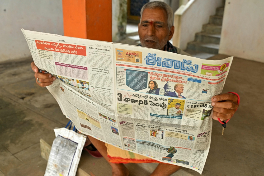 A villager reads a newspaper featuring US Republican party presidential candidate Donald Trump ® and US Democratic party presidential candidate Kamala Harris in Vadluru, the ancestral village of Usha Vance’s parents, wife of US Senator and Republican vice-presidential candidate JD Vance, at the West Godavari district in India’s Andhra Pradesh state November 5, 2024. — AFP pic