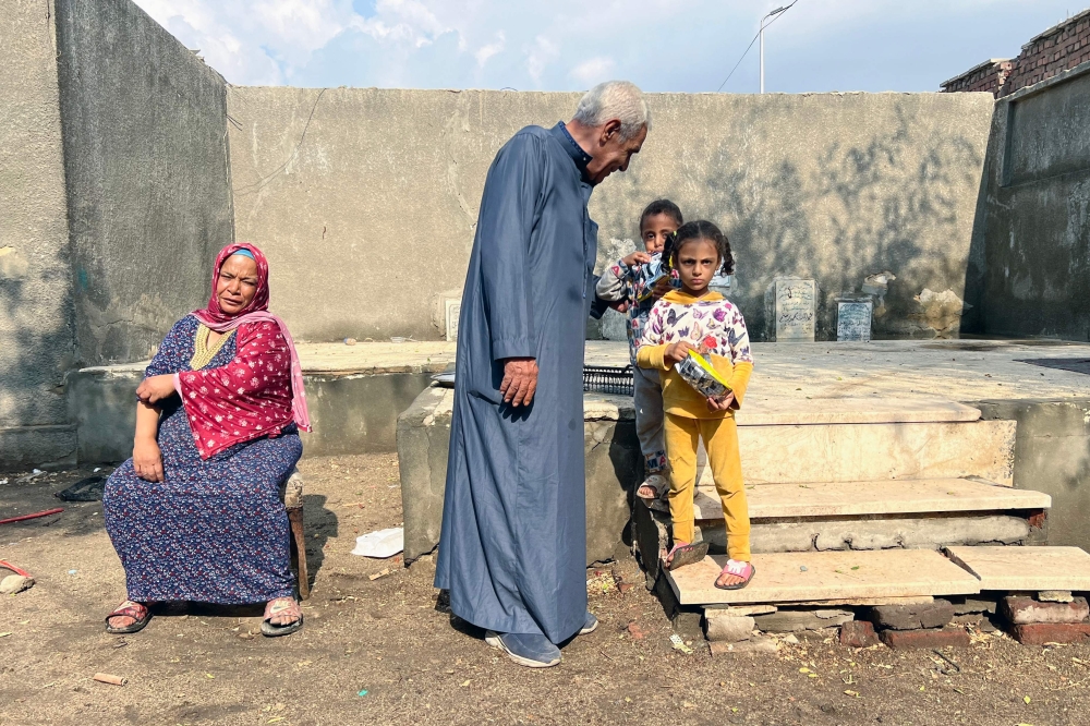 Sayyed al-Arabi, 71, who has lived and guarded the Ain Al-Sira cemetery in Old Cairo, for decades, speak to his granddaughters on November 4, 2024, before the demolition of the graveyard. — AFP pic