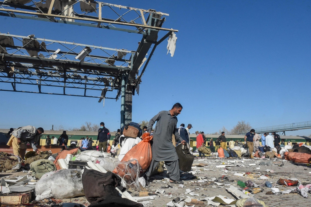 A man carries passengers' belongings from the blast site after an explosion at a railway station in Quetta, in Pakistan's Balochistan province on November 9, 2024. — AFP pic 