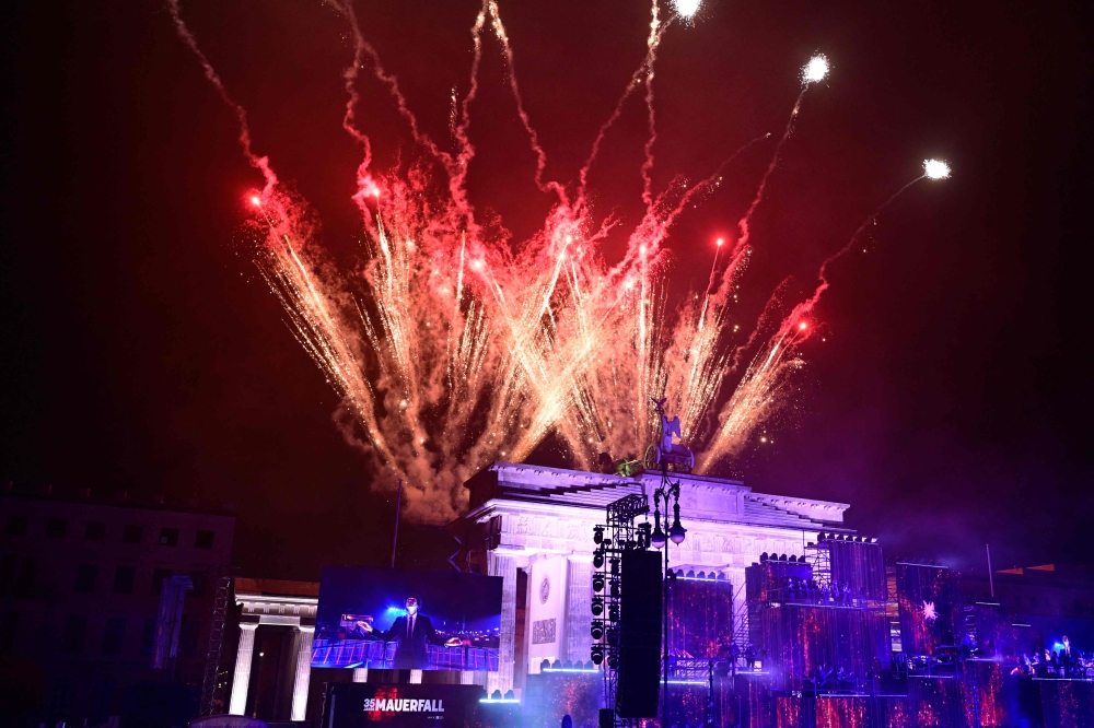 Fireworks ligthen the sky over the Brandenburg gate as musicians play on stage during the  ‘Konzert für Freiheit’ (concert for freedom) for the 35th anniversary of the fall of the Berlin Wall, on November 9, 2024 in Berlin. Germany yesterday celebrates 35 years since the fall of the Berlin Wall ushered in the end of communism and national reunification. — AFP pic