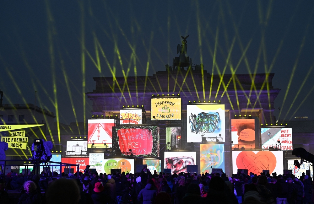 The Brandenburg gate is illuminated during celebrations marking the 35th anniversary of the fall of the Berlin Wall in Berlin on November 9, 2024. — AFP pic