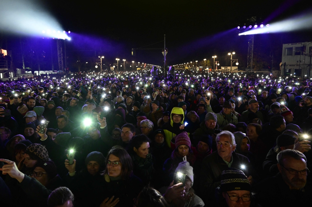 Spectators raise their smartphones' lights at the beginning of the concert where hundreds of musicians play on stage during the ‘Konzert für Freiheit’ (concert for freedom) for the 35th anniversary of the fall of the Berlin Wall, on November 9, 2024 at the Brandenburg Gate in Berlin. — AFP pic